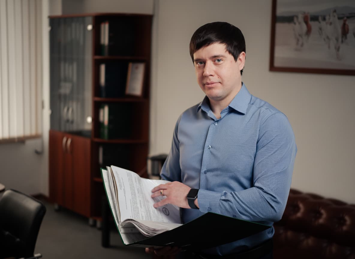 Юрист по банкротству физических лиц Дмитрий Боровик изучает документы дела клиента в офисе в Красноярске